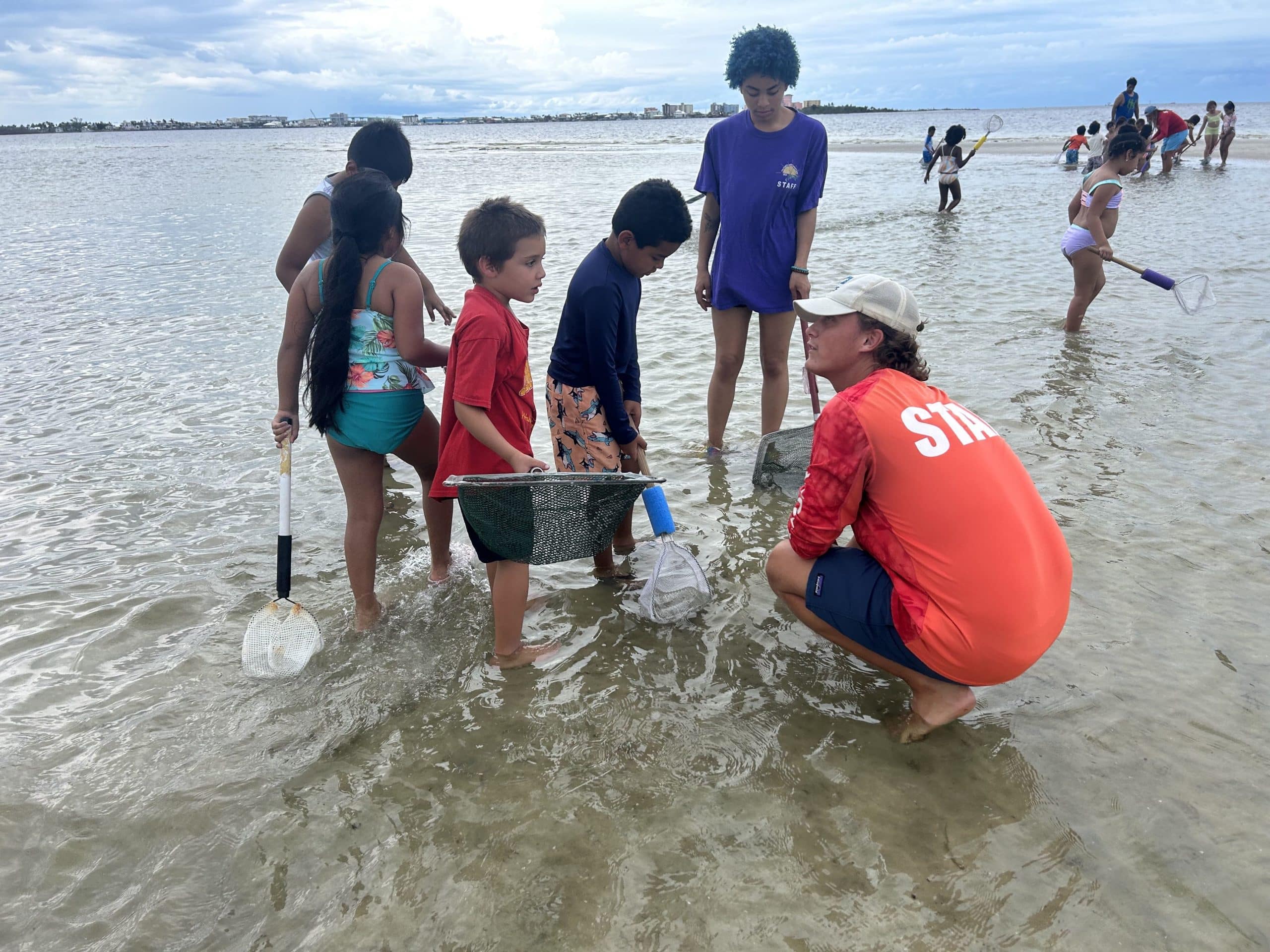 Marine Educator Austin Wise discovers a beach find with A Chance to Sea students on Bunche Beach.