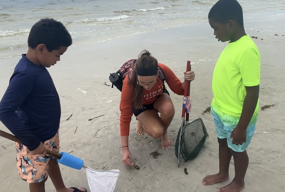 Marine science educator Annie Clinton dissects manatee poop with interested Sanibel Sea School students.