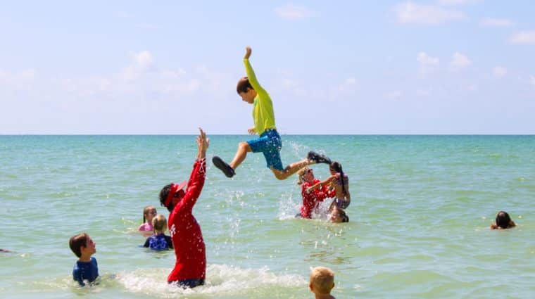 kids having fun in ocean with counselors during Sanibel Sea School summer camp